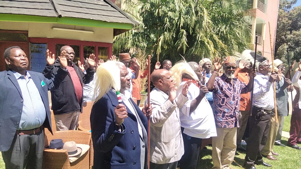 Council of Elders in traditional regalia, hands raised in blessing